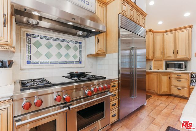 a kitchen with wooden cabinets and a stove top oven
