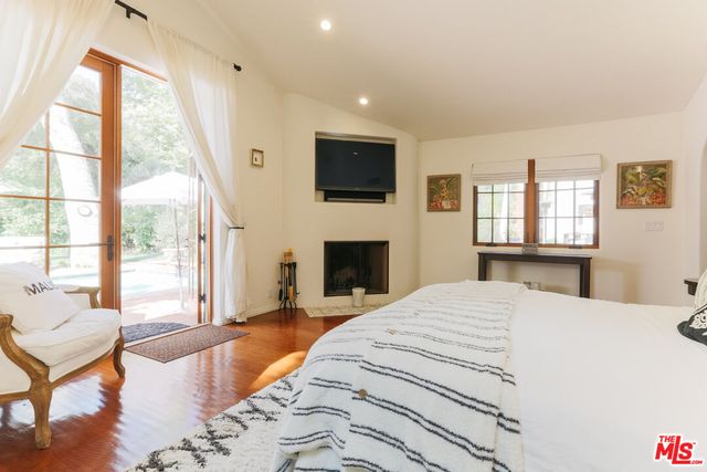 a spacious bedroom with a large bed and a flat screen tv