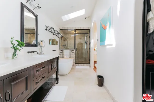 a bathroom with a double vanity sink a mirror and a shower