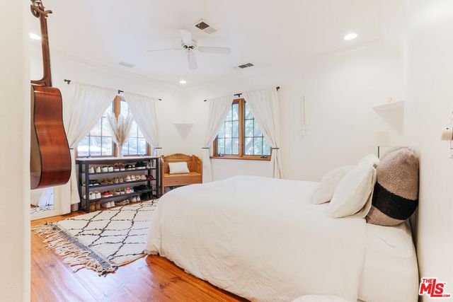 a bedroom with a bed and wooden floor