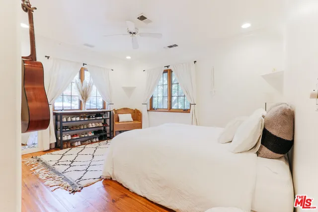 a bedroom with a bed and wooden floor