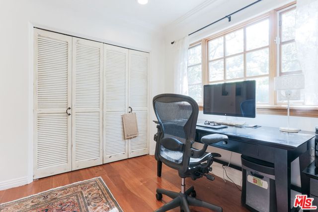 a view of a workspace with furniture and a window