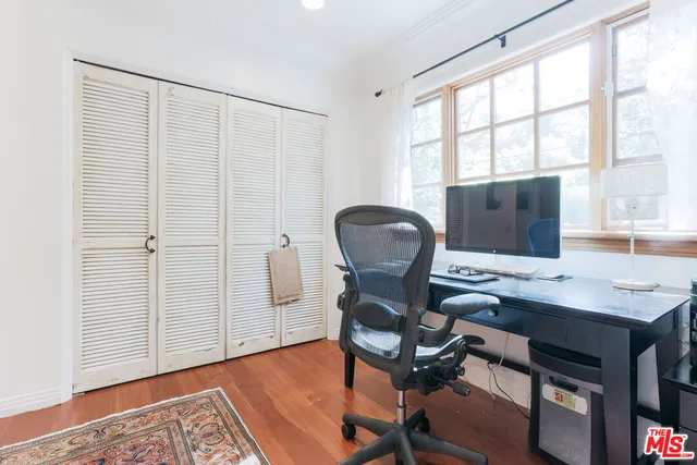 a view of a workspace with furniture and a window
