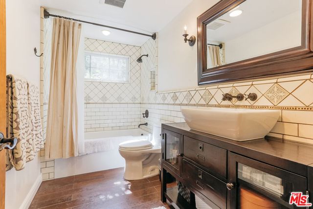 a bathroom with a sink toilet a mirror and shower