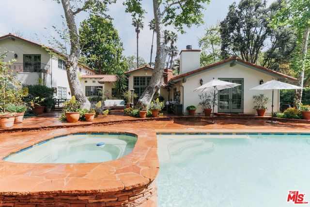 a view of a house with swimming pool and sitting area