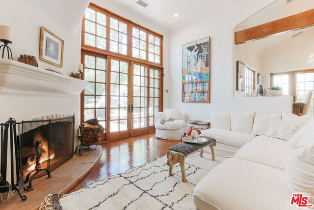 a living room with furniture a fireplace and a floor to ceiling window