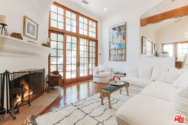 a living room with furniture a fireplace and a floor to ceiling window