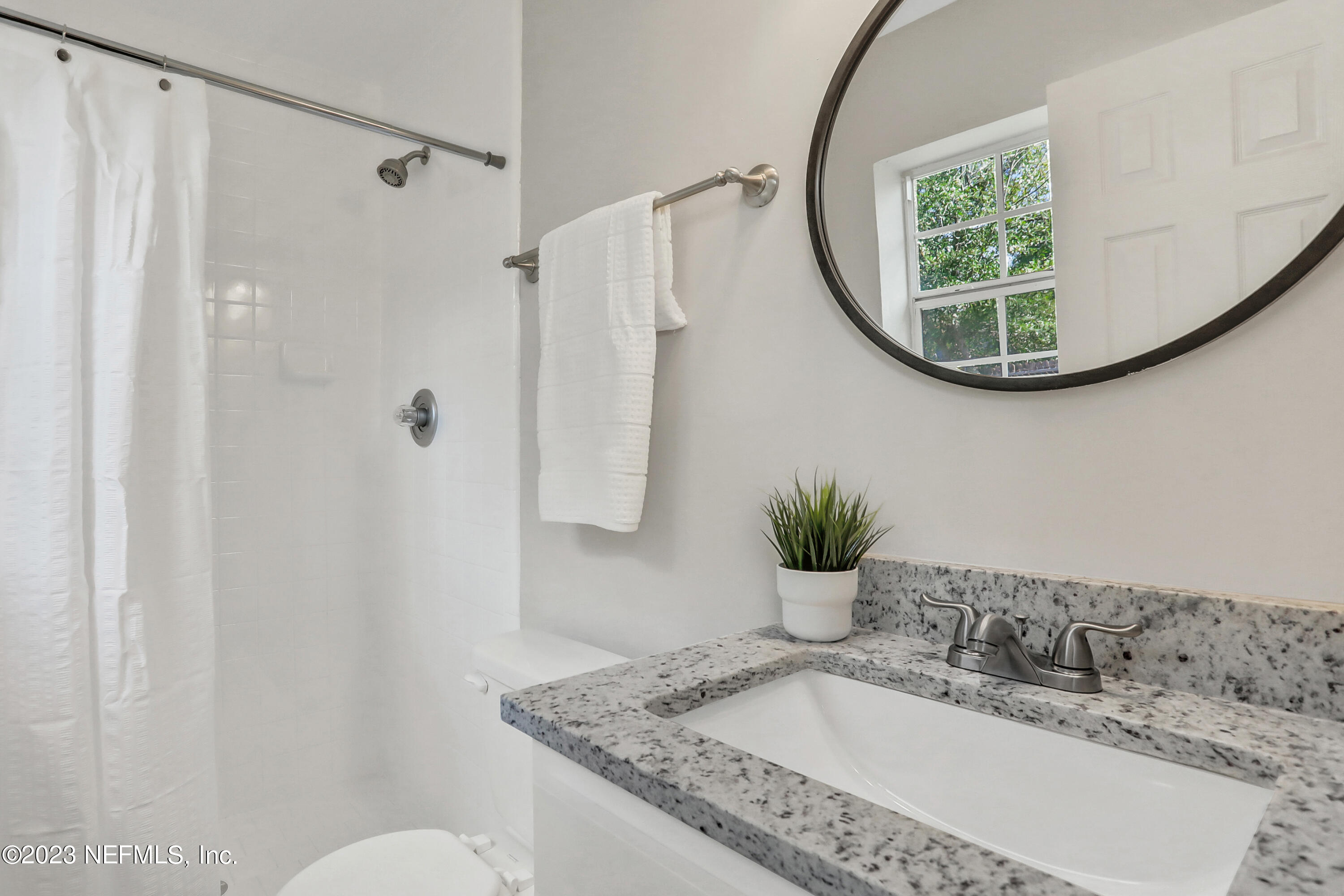 5922 Ridgeway Road East Jacksonville, FL 32244 - Photo 18 of 35 a bathroom with a granite countertop sink a mirror and a bathtub