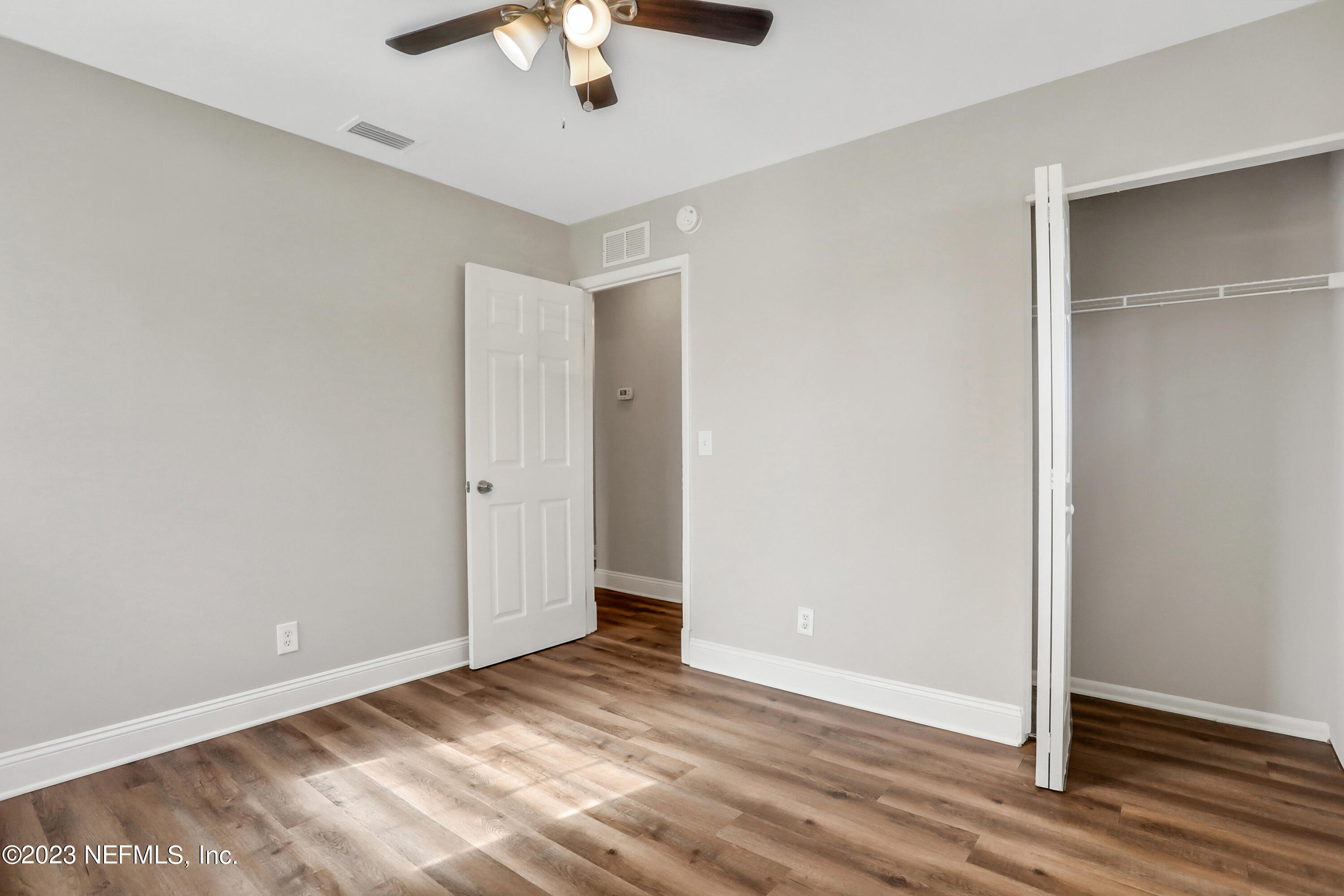 5922 Ridgeway Road East Jacksonville, FL 32244 - Photo 21 of 35 an empty room with wooden floor chandelier fan and closet area