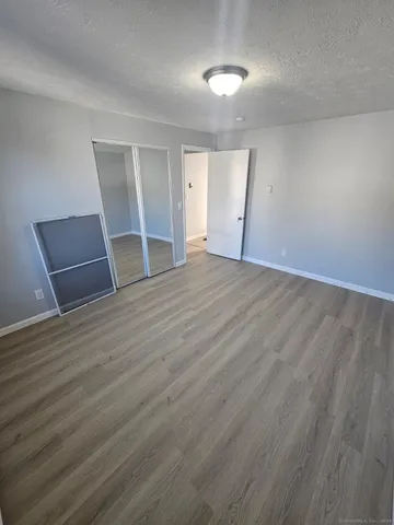 an empty room with wooden floor and entrance