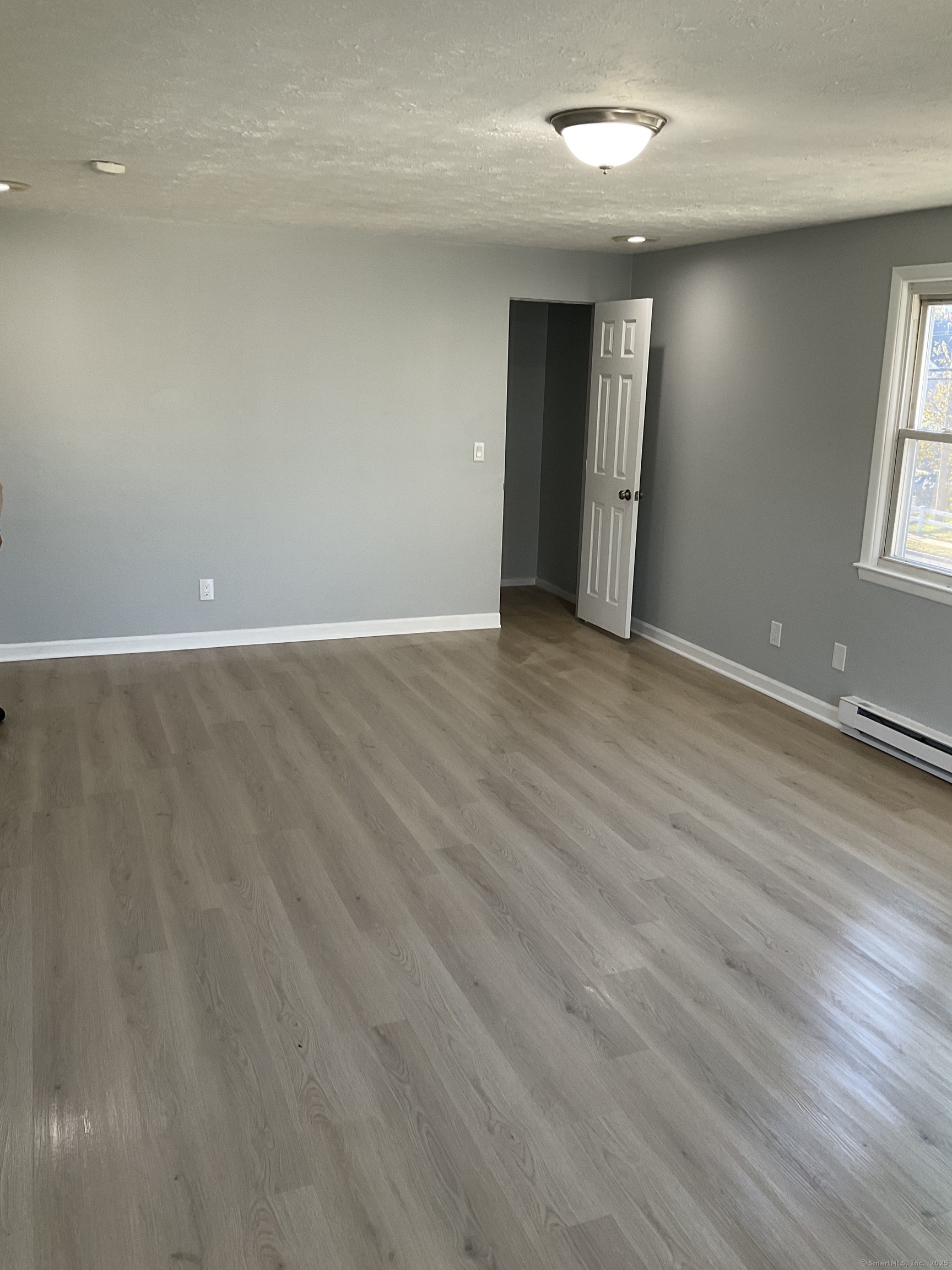 641 Middletown Avenue, Unit 2 New Haven, CT 06513 - Photo 15 of 20 an empty room with wooden floor and windows