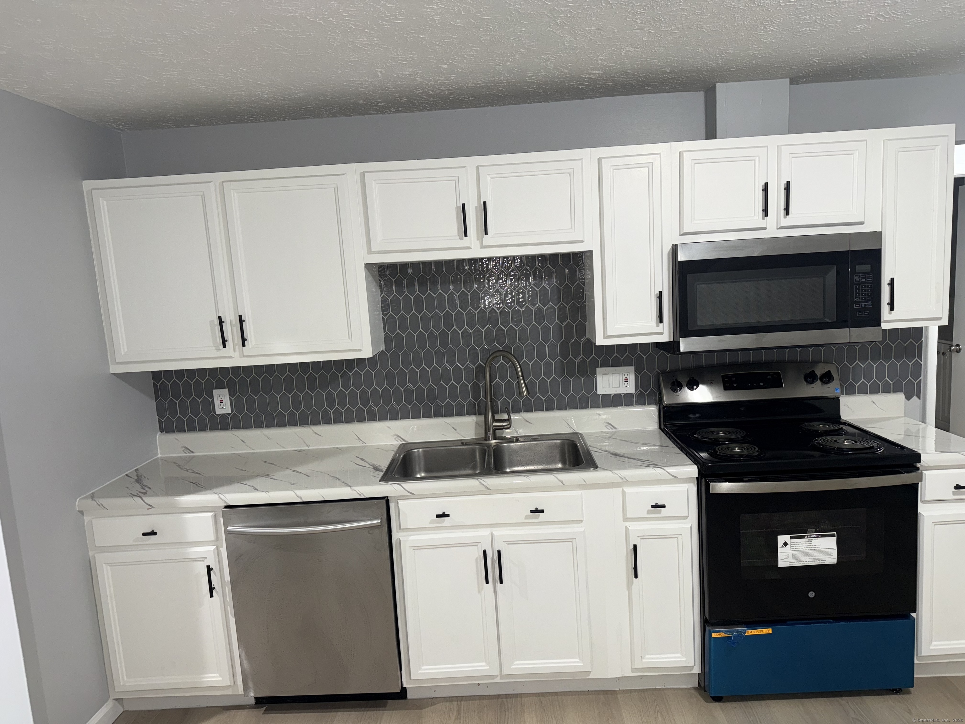 641 Middletown Avenue, Unit 2 New Haven, CT 06513 - Photo 3 of 20 a kitchen with stainless steel appliances a stove a microwave and cabinets