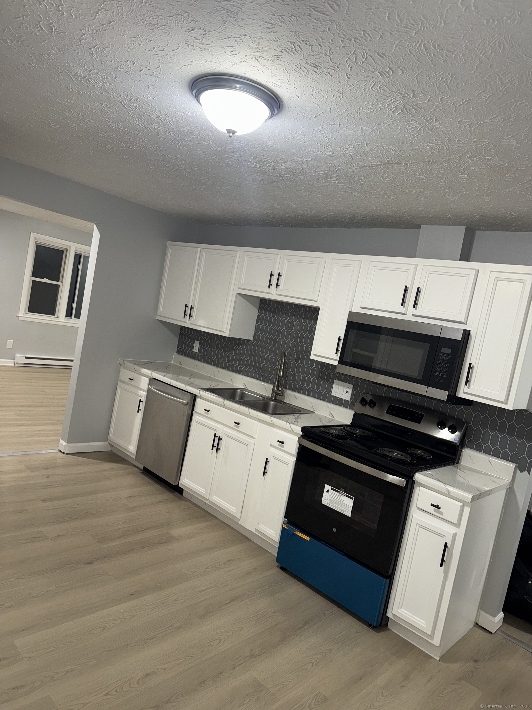 641 Middletown Avenue, Unit 2 New Haven, CT 06513 - Photo 4 of 20 a kitchen with stainless steel appliances a stove a sink and white cabinets