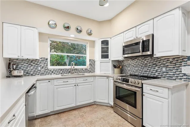 a kitchen with cabinets appliances and a window