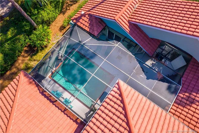 an aerial view of a residential houses with outdoor space and swimming pool