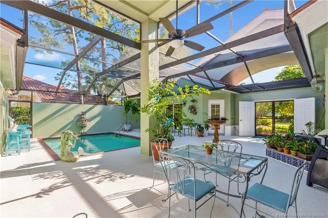 a kitchen with stainless steel appliances granite countertop a stove top oven a sink dishwasher a dining table and chairs with wooden floor