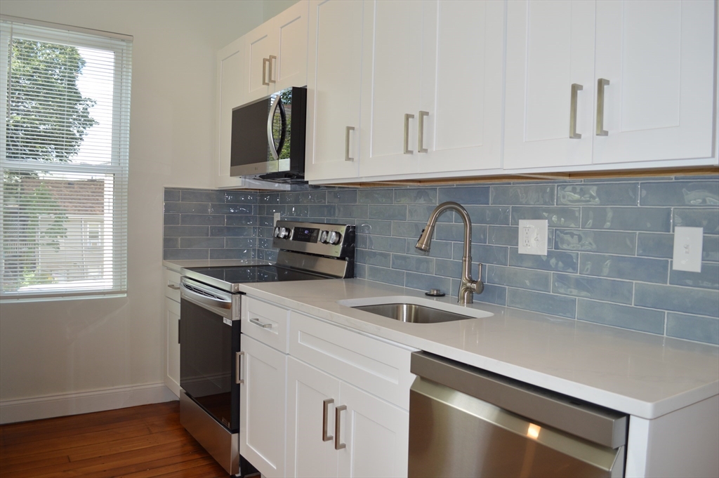 a kitchen with stainless steel appliances granite countertop a sink stove and microwave
