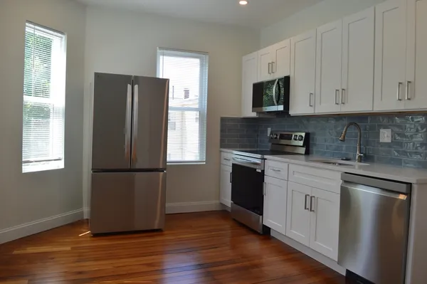 a kitchen with a refrigerator stove and wooden cabinets