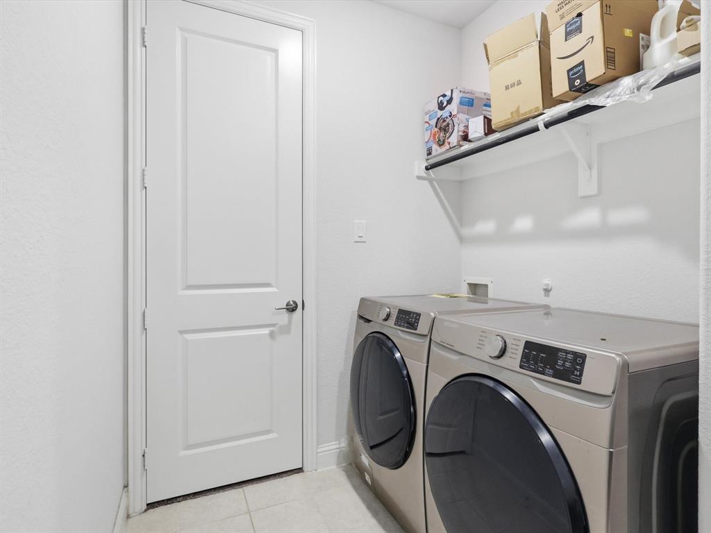 16458 Ryder Rock Road Frisco, TX 75033 - Photo 22 of 24 a view of washer and dryer with kitchen in the background