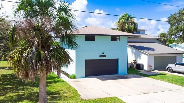 a front view of yellow house with a yard