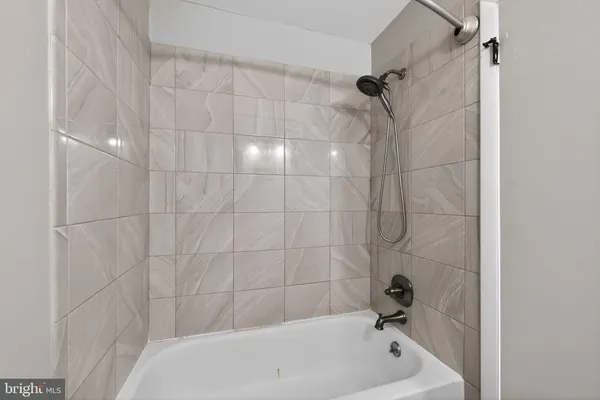 a bathroom with a white bath tub and a shower