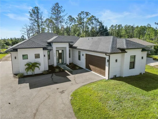 a house with green field in front of it