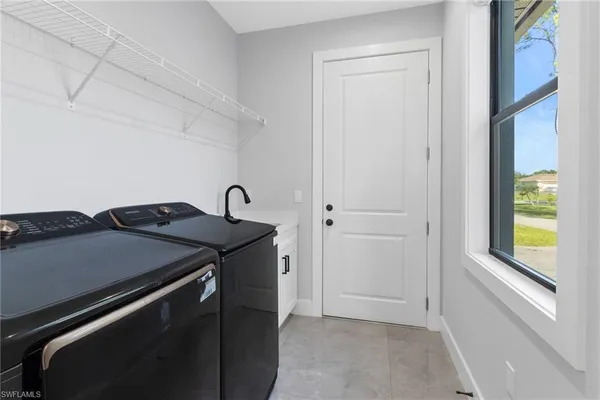 a utility room with dryer and window