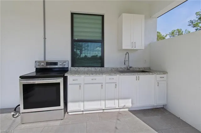 a kitchen with granite countertop white cabinets and white appliances