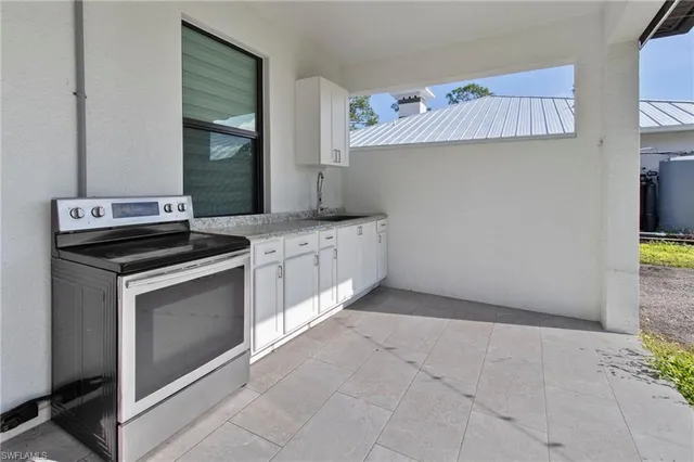 a kitchen with granite countertop a stove sink and cabinets