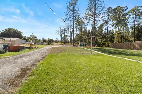a backyard of a house with lots of green space and fountain