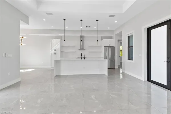 a view of a kitchen with refrigerator and window
