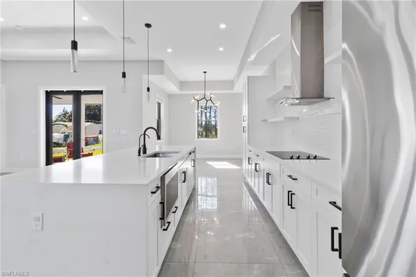 a kitchen with stainless steel appliances granite countertop a sink and a refrigerator