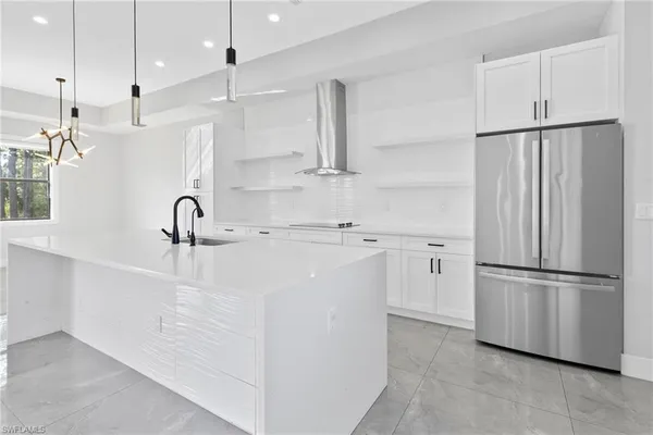 a kitchen with kitchen island white cabinets and stainless steel appliances