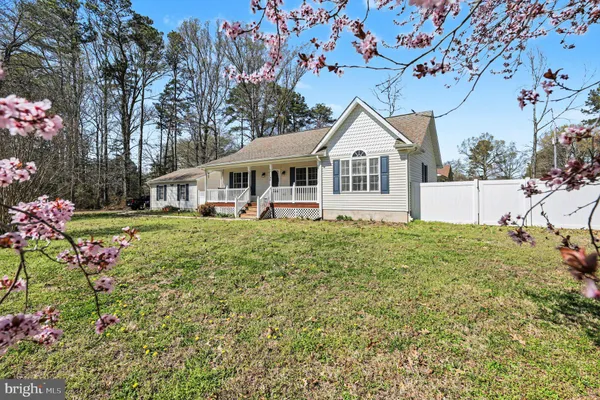 a view of a house with a big yard and large trees