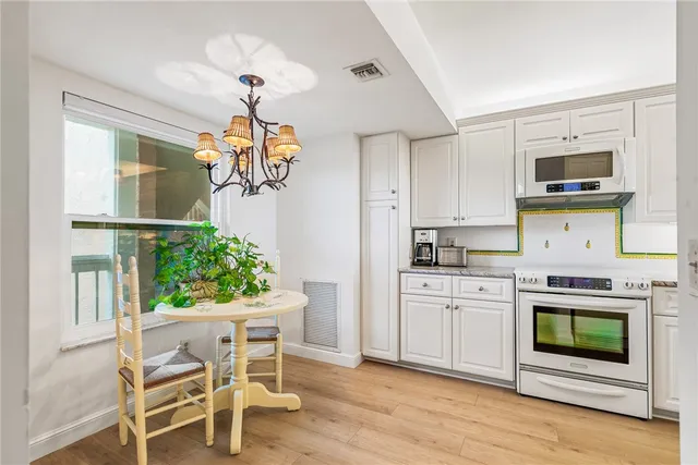 a kitchen with stainless steel appliances granite countertop a stove and cabinets