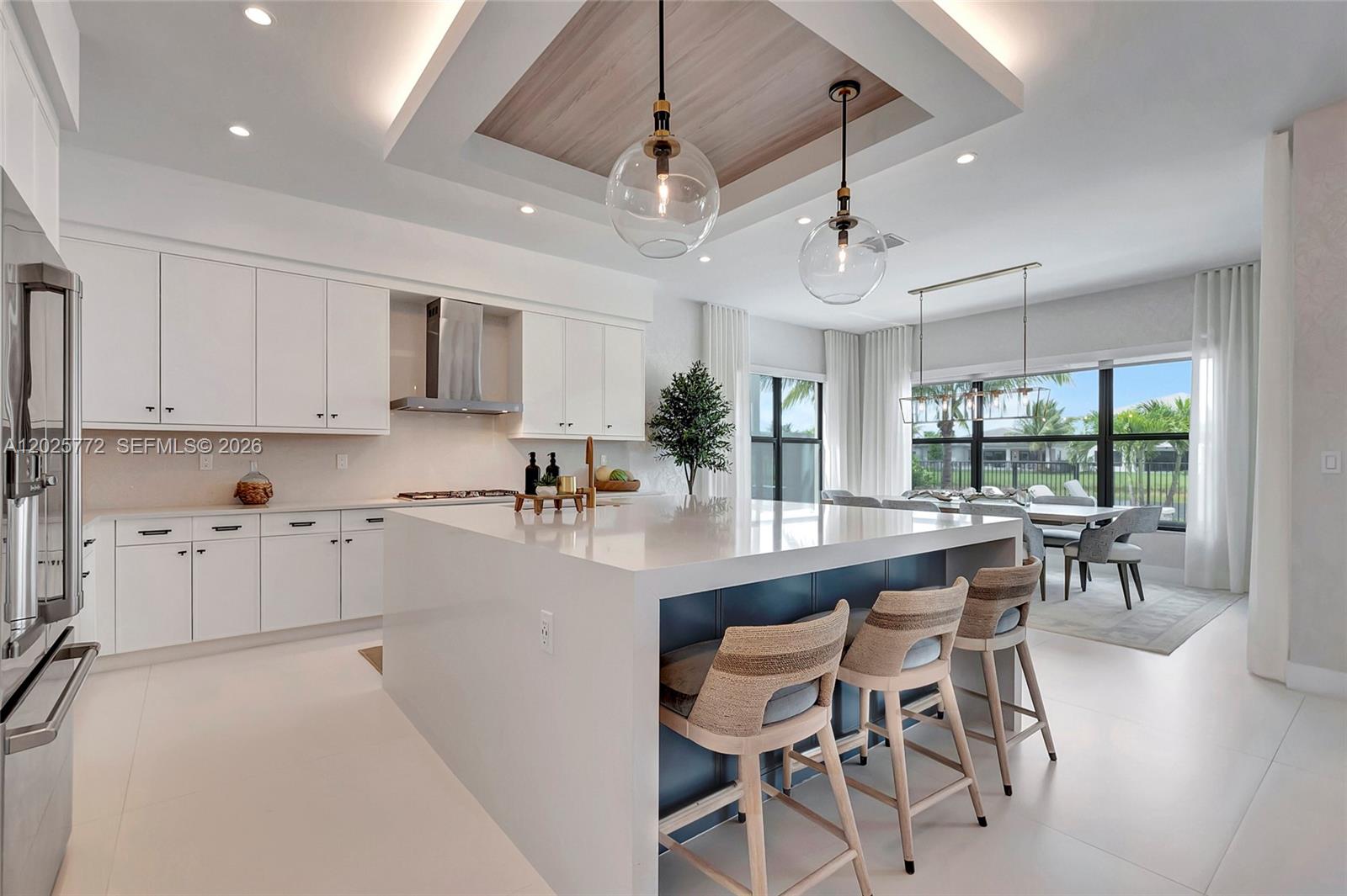 17023 Wandering Wave Avenue Boca Raton, FL 33496 - Photo 22 of 84 a kitchen with stainless steel appliances granite countertop a stove top oven a sink a dining table and chairs with white cabinets