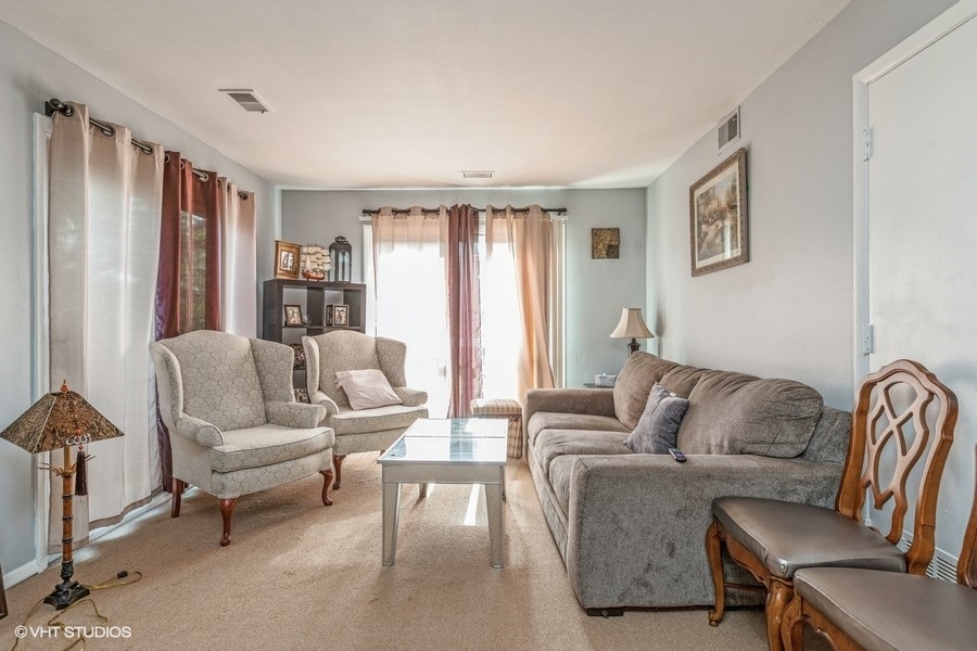 1870 Huntington Boulevard, Unit E Hoffman Estates, IL 60169 - Photo 3 of 10 a living room with furniture and a large window