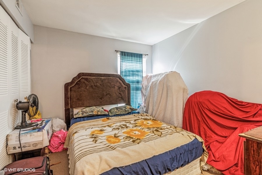 1870 Huntington Boulevard, Unit E Hoffman Estates, IL 60169 - Photo 6 of 10 a bedroom with a bed and dresser
