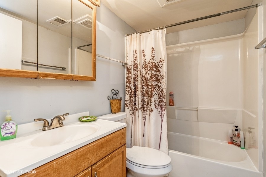 1870 Huntington Boulevard, Unit E Hoffman Estates, IL 60169 - Photo 8 of 10 a bathroom with a sink toilet and shower