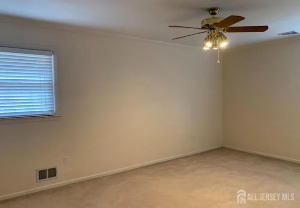 an empty room with a fan and a window
