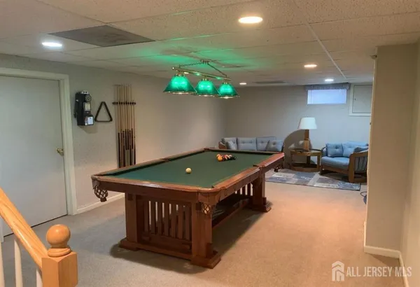 a room with furniture pool table and window