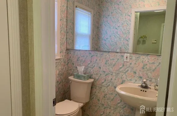 a bathroom with a toilet sink and mirror