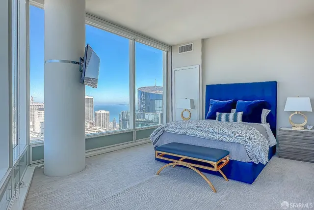 a spacious bedroom with a bed and glass window