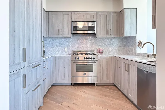 a kitchen with stainless steel appliances a sink stove and cabinets