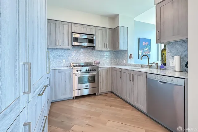 a kitchen with white cabinets stainless steel appliances and sink