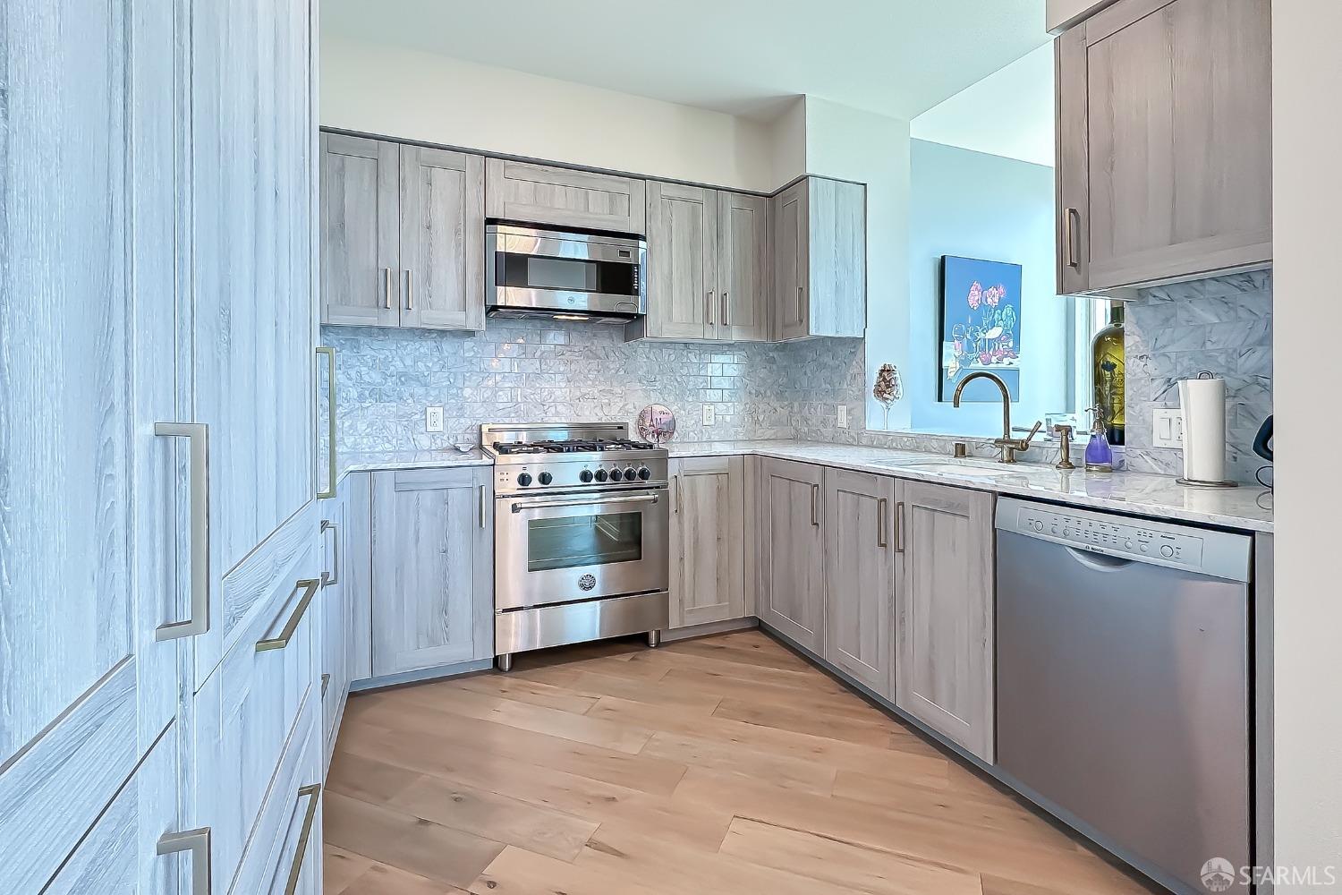 401 Harrison Street, Unit 44A San Francisco, CA 94105 - Photo 6 of 42 a kitchen with stainless steel appliances a sink stove and cabinets