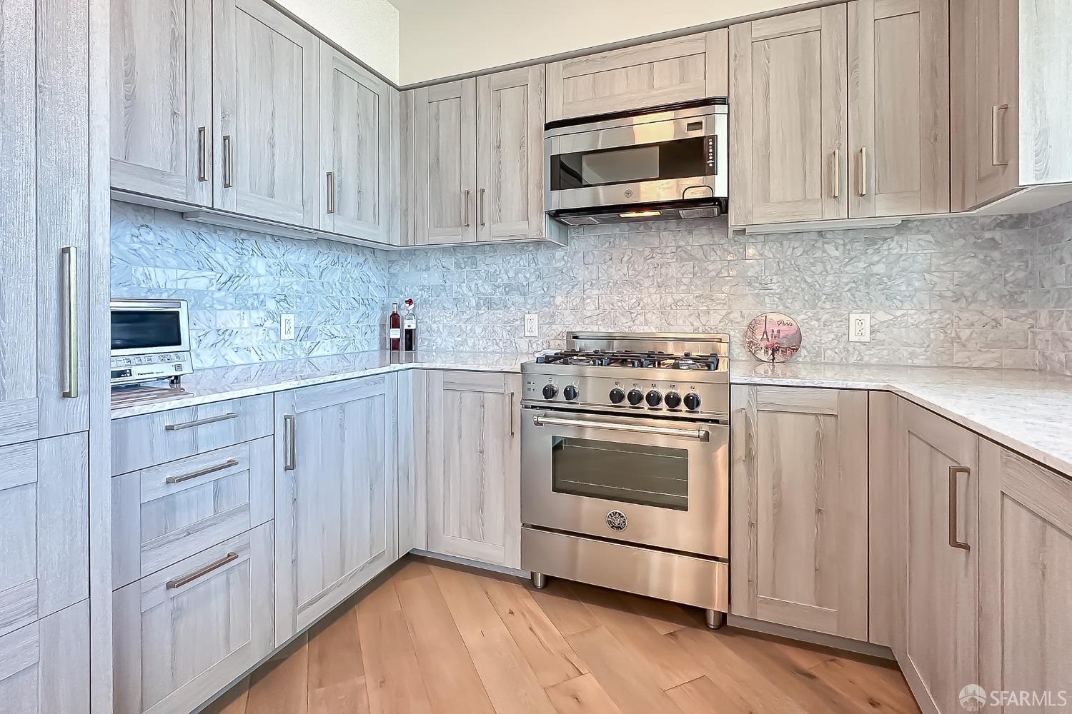 401 Harrison Street, Unit 44A San Francisco, CA 94105 - Photo 7 of 42 a kitchen with white cabinets stainless steel appliances and sink