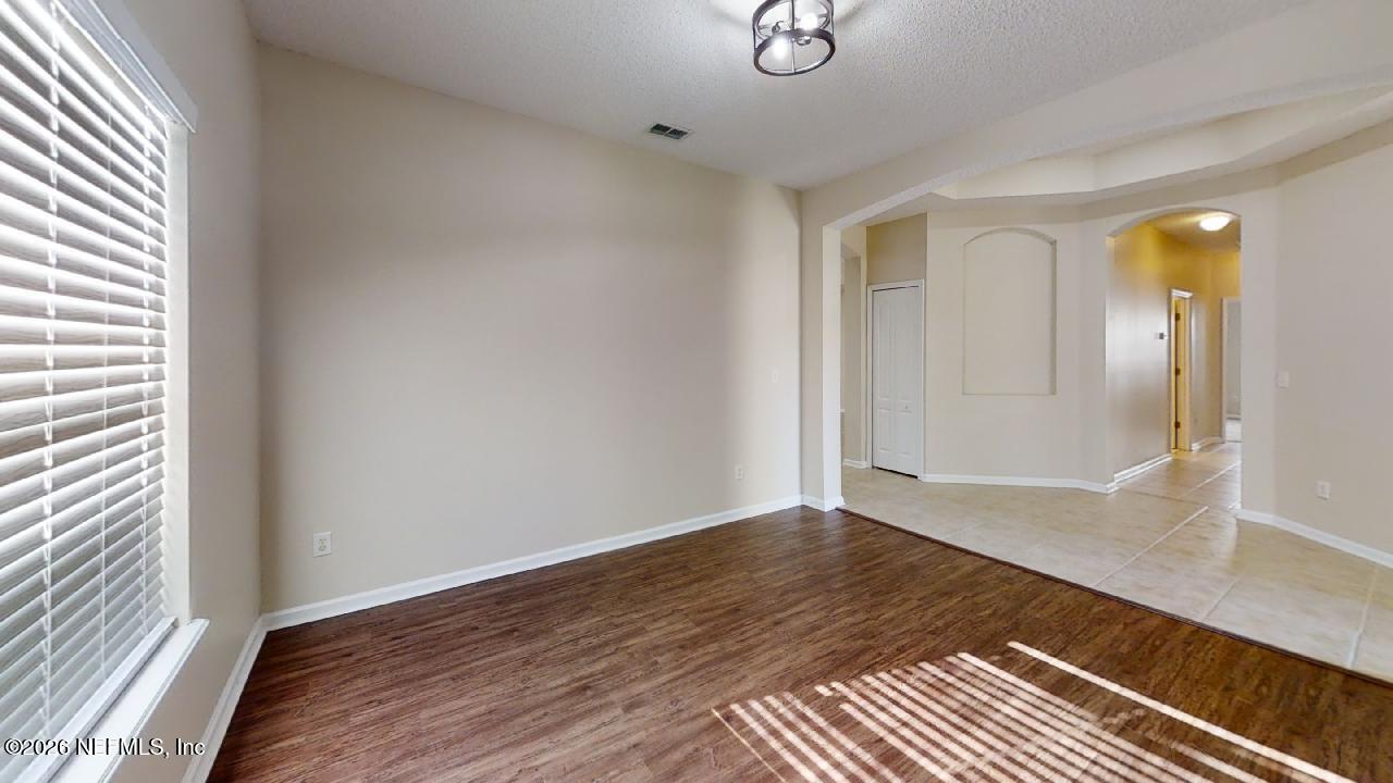 14454 Millhopper Road Jacksonville, FL 32258 - Photo 35 of 44 a view of an empty room with wooden floor and a window