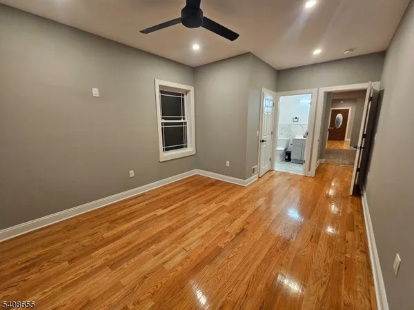an empty room with wooden floor and natural light