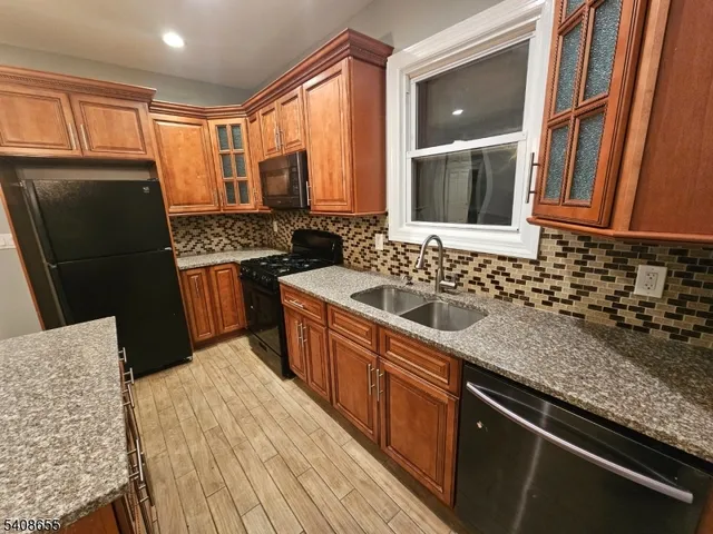 a kitchen with granite countertop a refrigerator and a sink